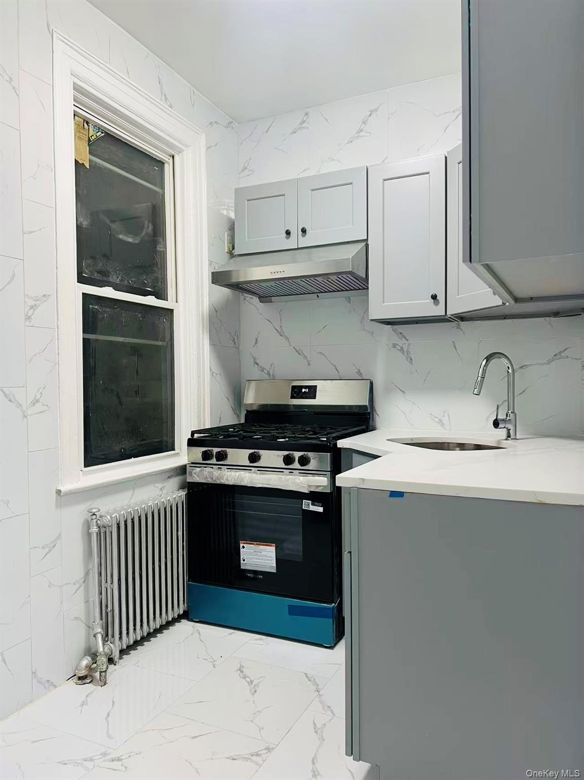 35-40 92nd Street, Unit 2FL FRONT Queens, NY 11372 - Photo 2 of 6 a kitchen with wooden cabinets and a stove top oven
