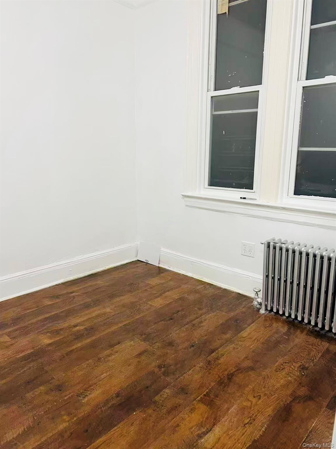 35-40 92nd Street, Unit 2FL FRONT Queens, NY 11372 - Photo 5 of 6 a view of an empty room with wooden floor and a window
