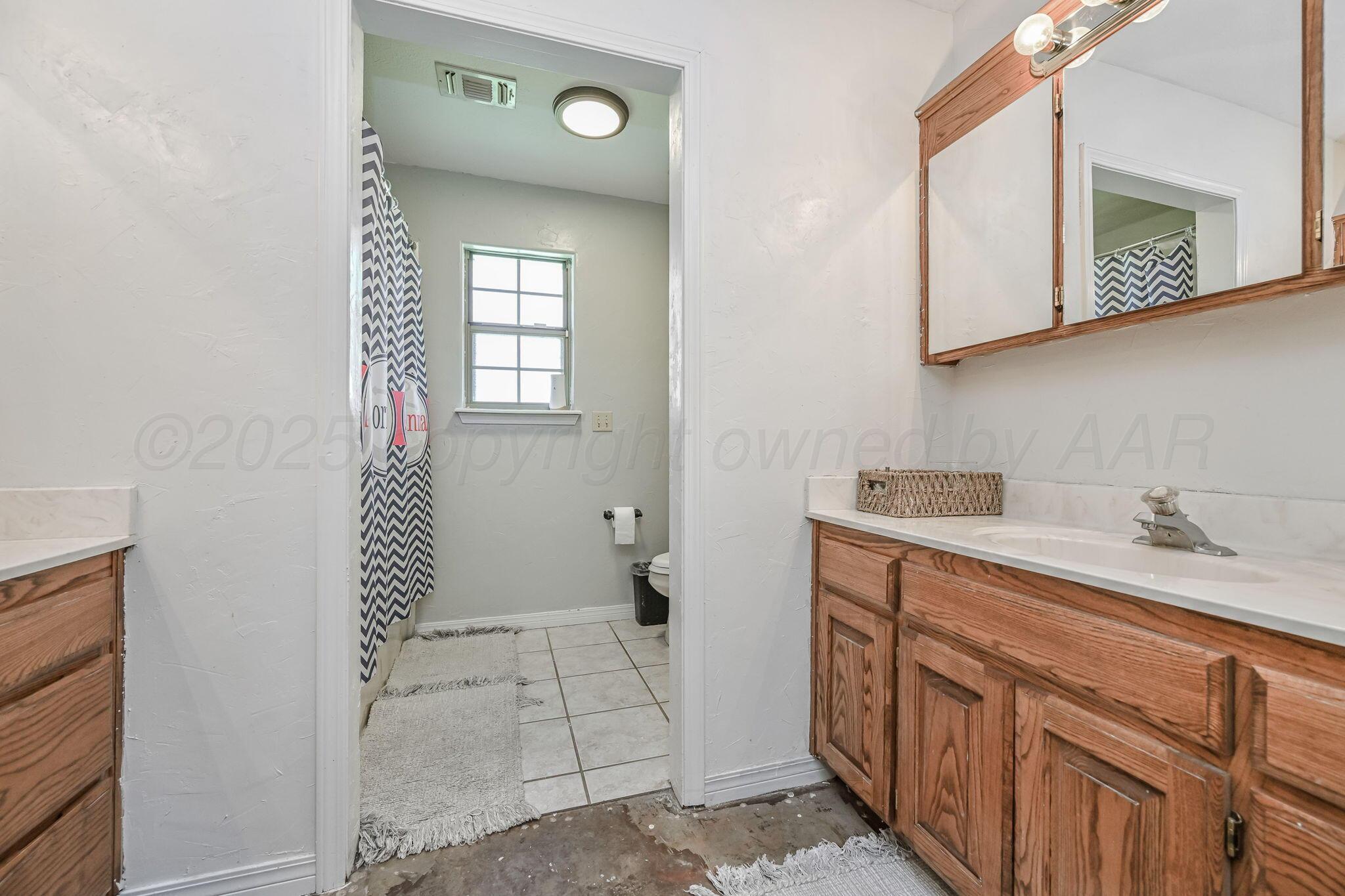 9151 Helium Road Amarillo, TX 79119 - Photo 14 of 49 a bathroom with a sink a toilet and mirror