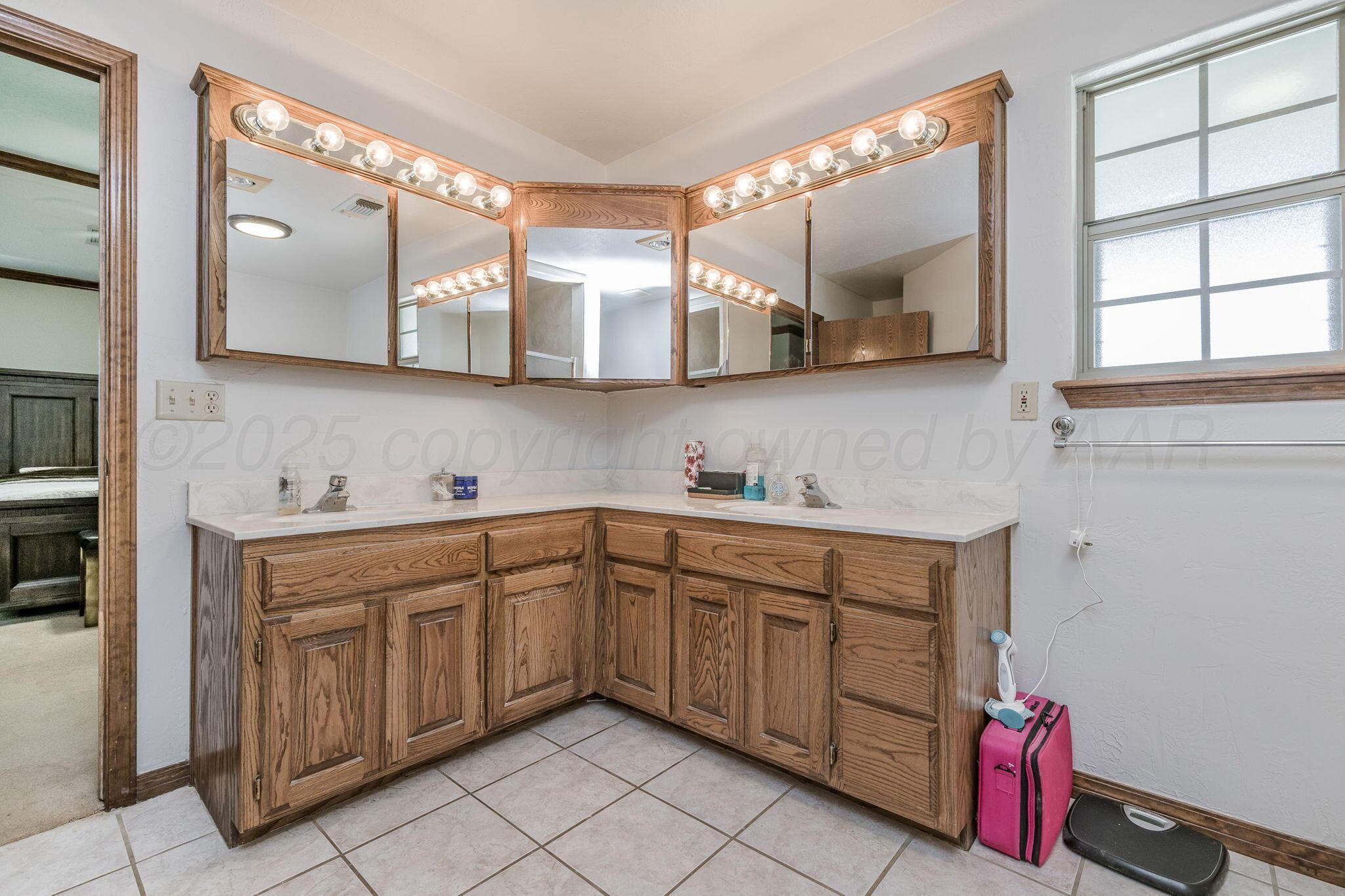 9151 Helium Road Amarillo, TX 79119 - Photo 17 of 49 a spacious bathroom with a double vanity sink mirror and window