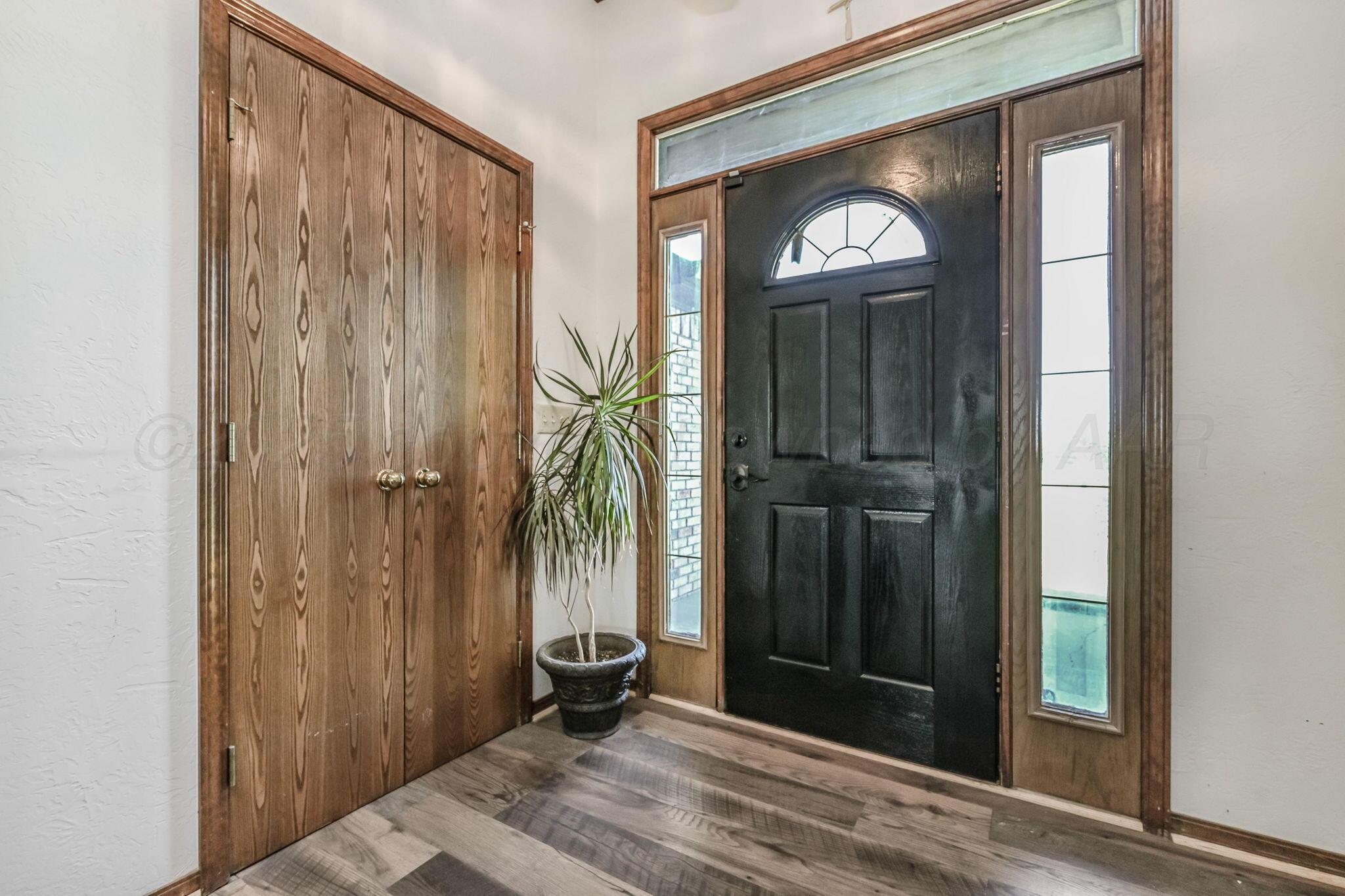 9151 Helium Road Amarillo, TX 79119 - Photo 2 of 49 a view of a hallway with wooden floor and a bathroom view
