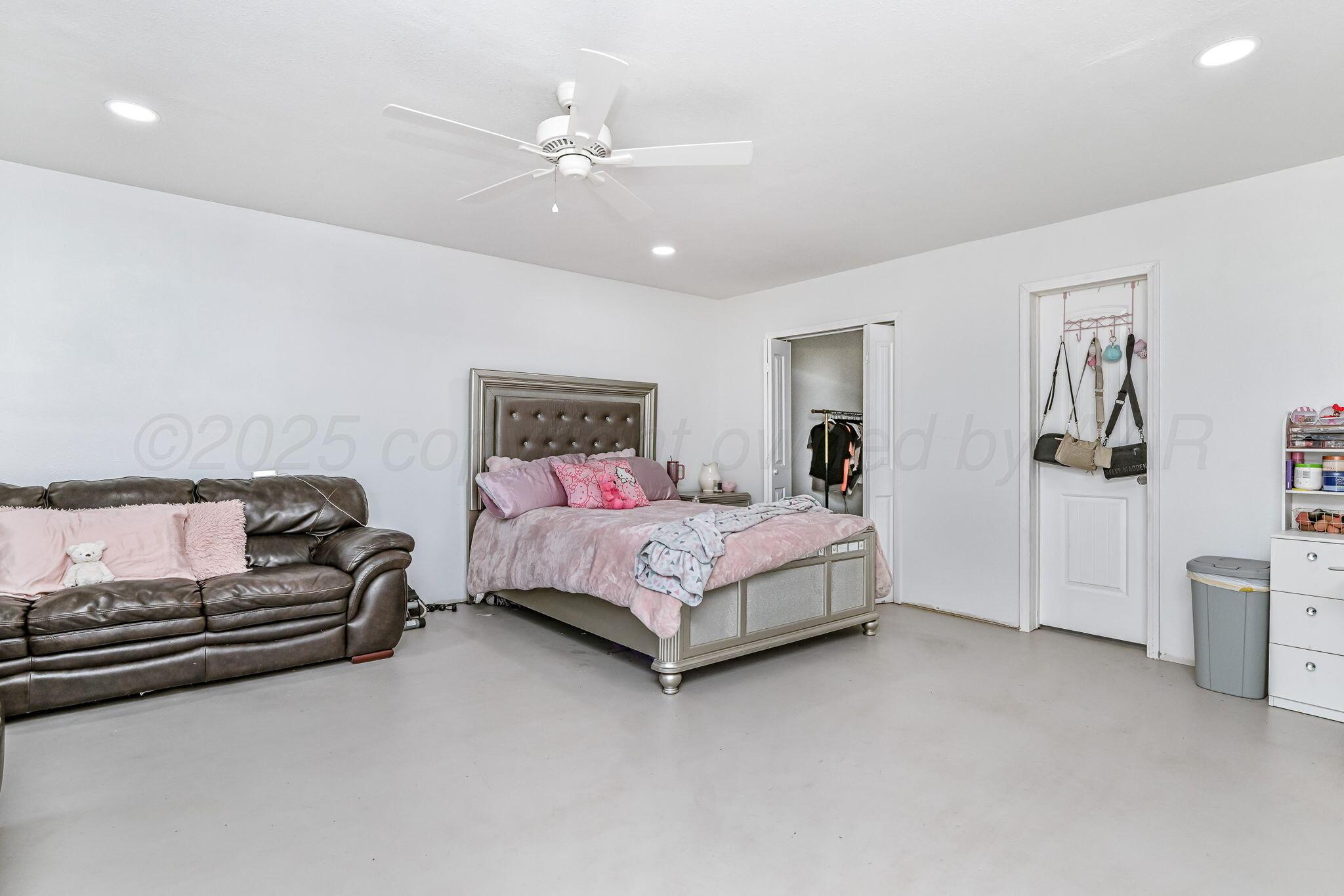 9151 Helium Road Amarillo, TX 79119 - Photo 26 of 49 a spacious bedroom with a bed and a cabinets