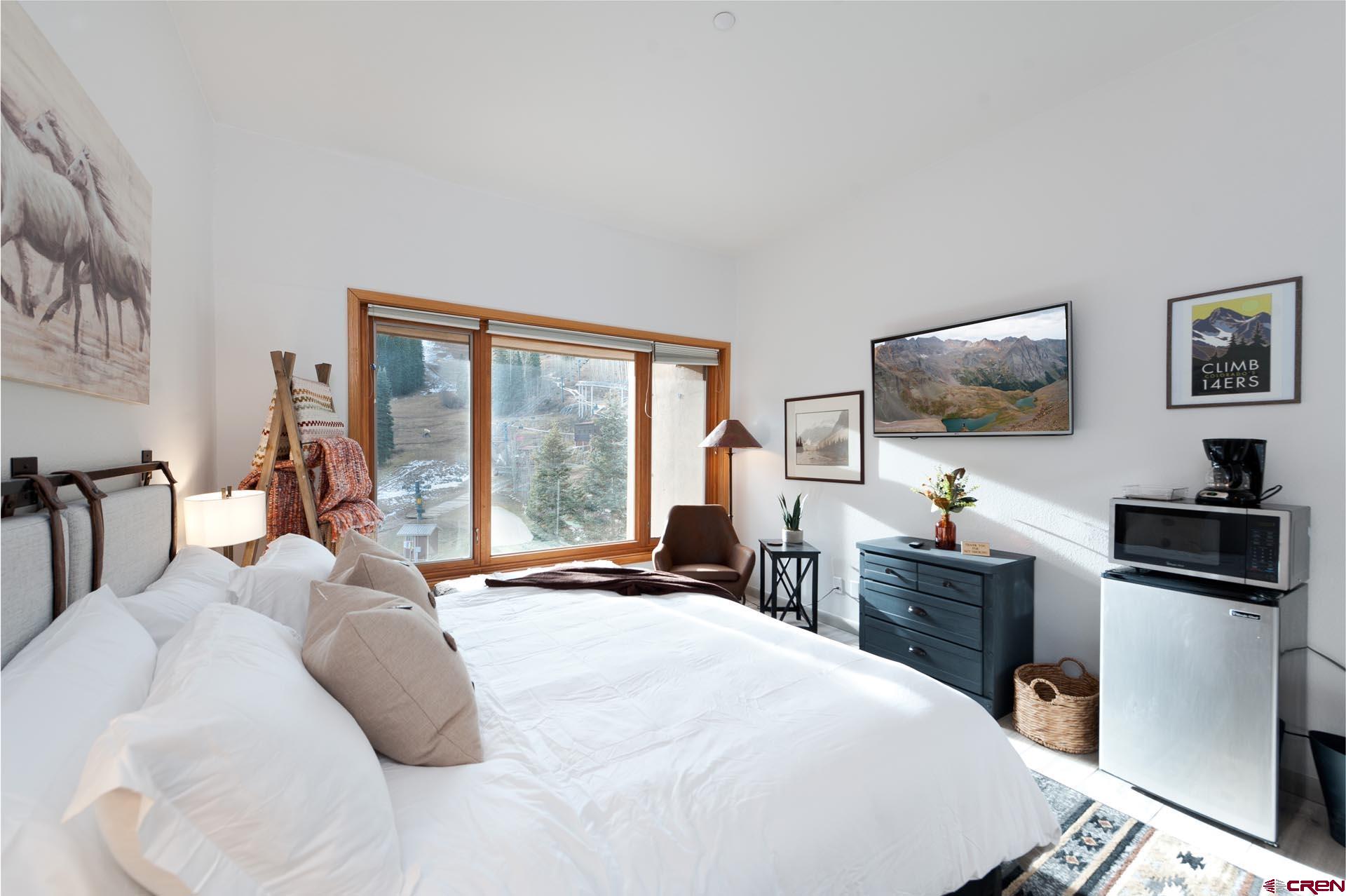 93 Needles Way, Unit 501 Durango, CO 81301 - Photo 19 of 32 a bedroom with a bed and a flat tv screen on dresser