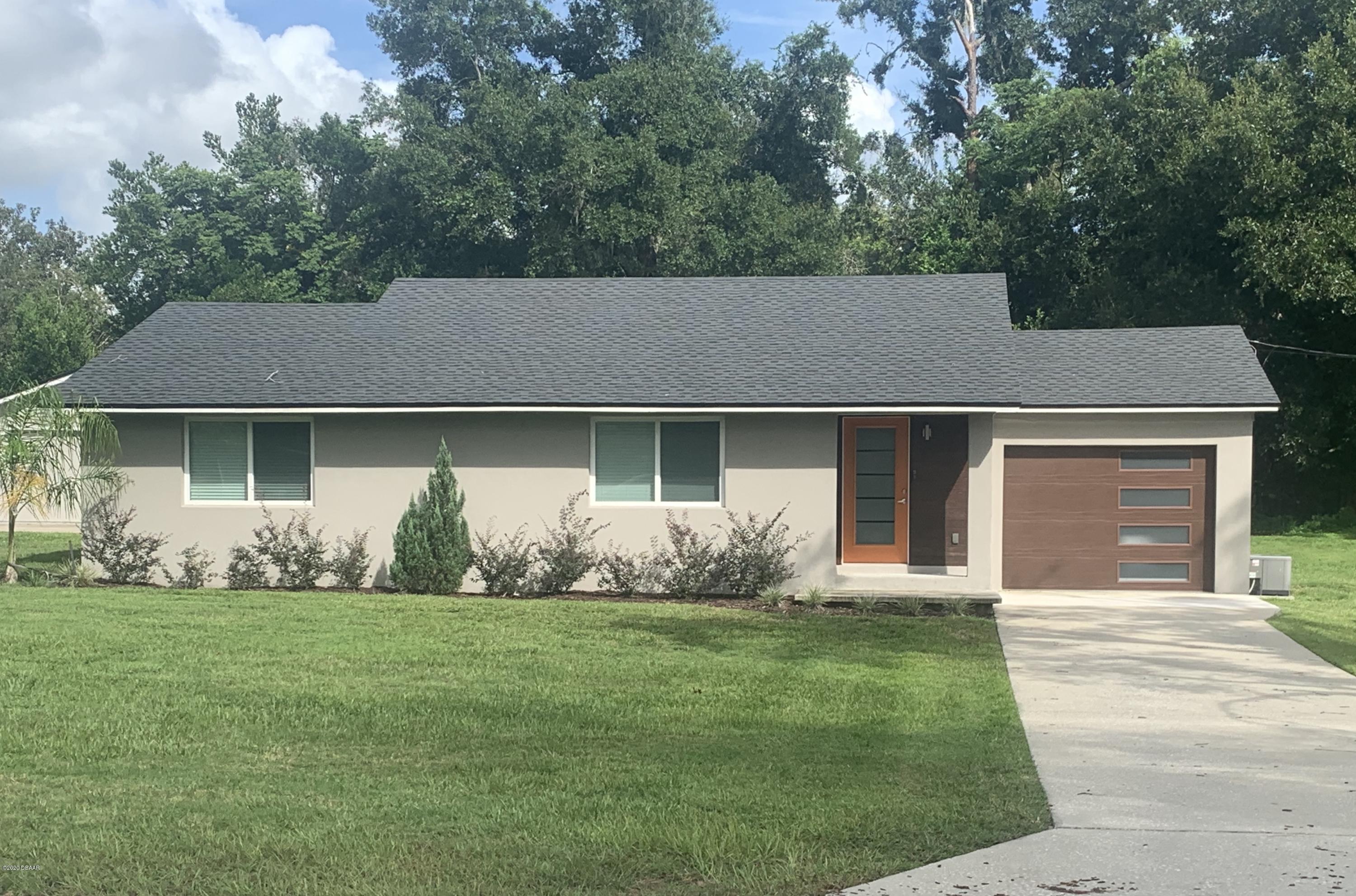 109 Floridana Road DeBary, FL 32713 - Photo 1 of 38 a front view of a house with a garden and yard