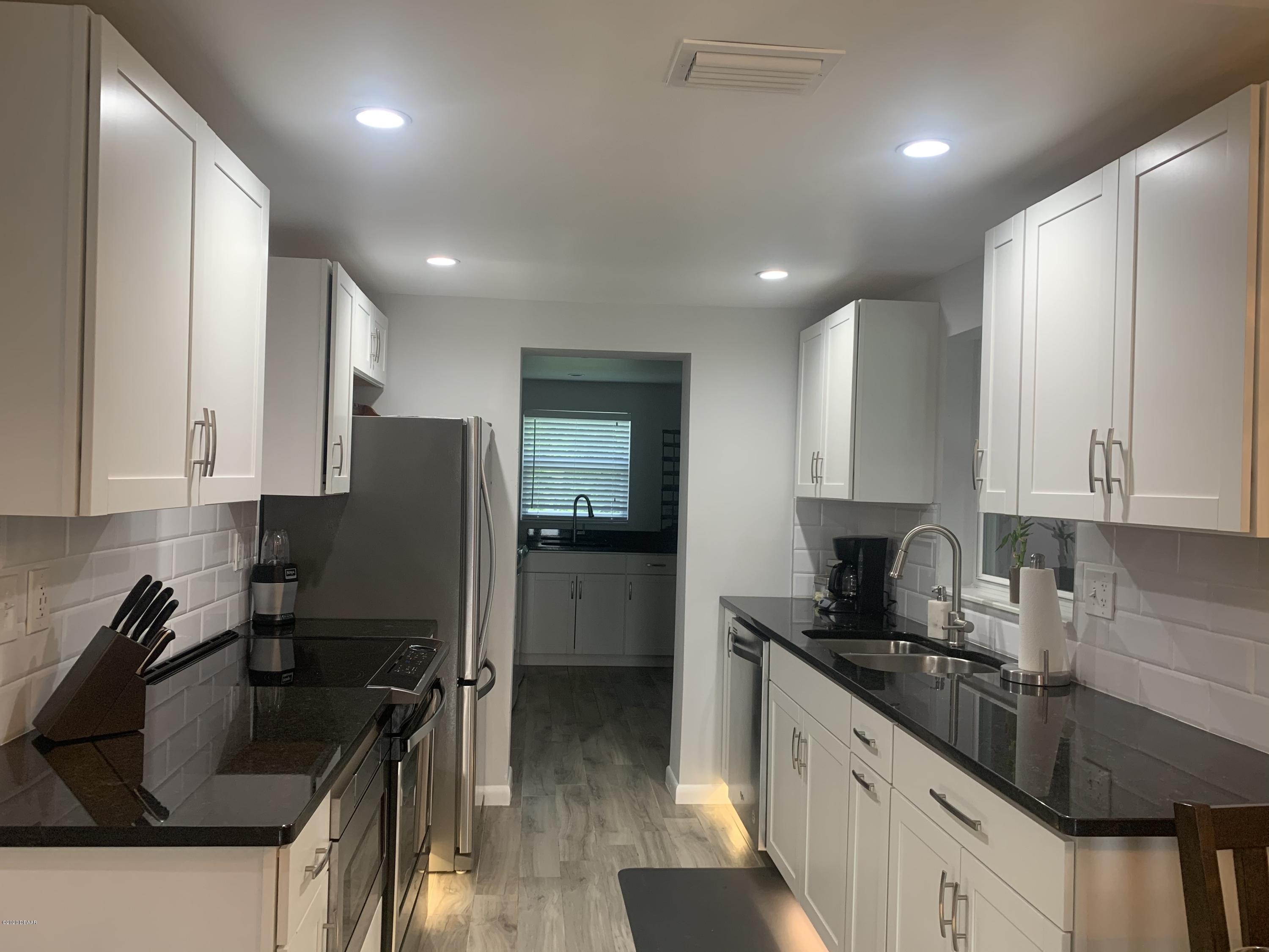 109 Floridana Road DeBary, FL 32713 - Photo 21 of 38 a kitchen with stainless steel appliances granite countertop a sink stove and refrigerator