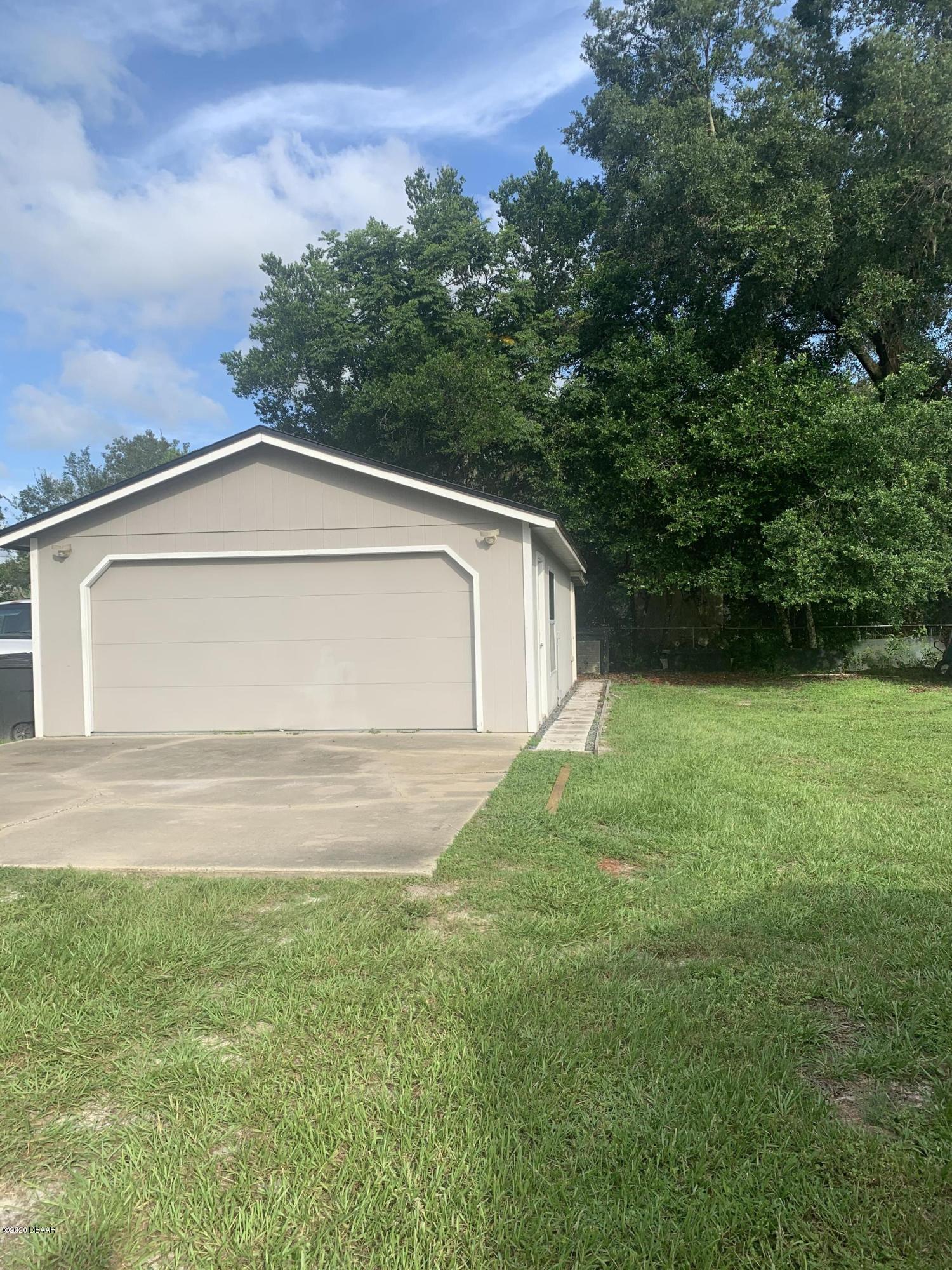 109 Floridana Road DeBary, FL 32713 - Photo 27 of 38 a white house with green field in front of it