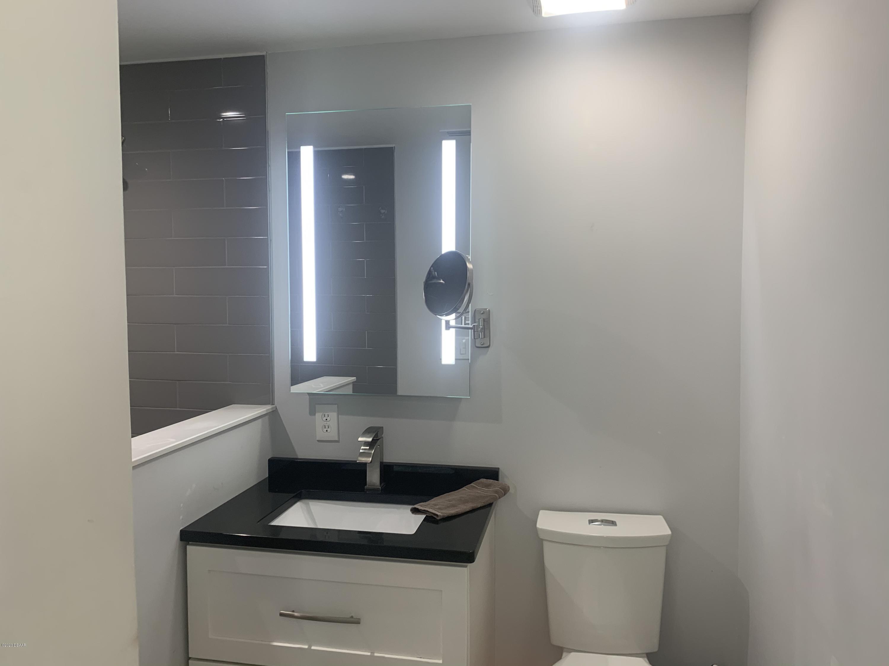 109 Floridana Road DeBary, FL 32713 - Photo 8 of 38 a bathroom with a toilet a sink and mirror