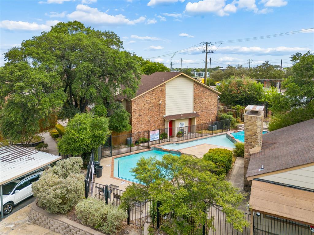 11311 Audelia Road, Unit 102 Dallas, TX 75243 - Photo 27 of 31 Brick exterior building with multiple swimming pools, mature trees, and a covered parking area