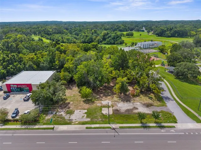 an aerial view of residential houses with outdoor space and trees