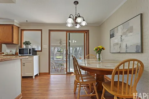 a dining room with furniture a chandelier and wooden floor