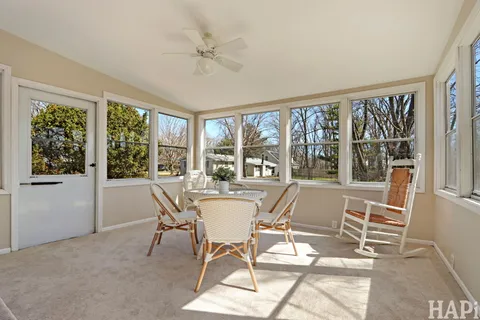 a view of a dining room with furniture large windows and chandelier