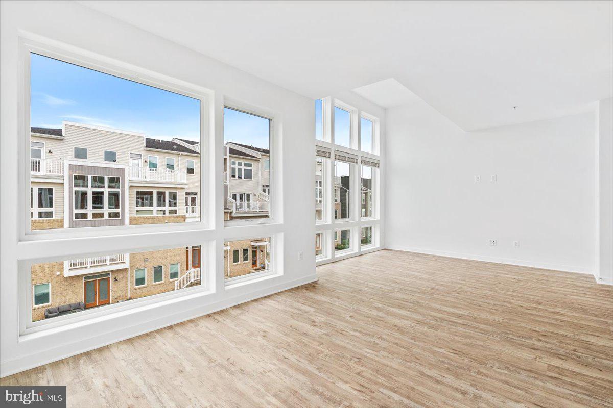 1618 A Blacksmith Way Frederick, MD 21702 - Photo 7 of 45 a view of an empty room with wooden floor and a window