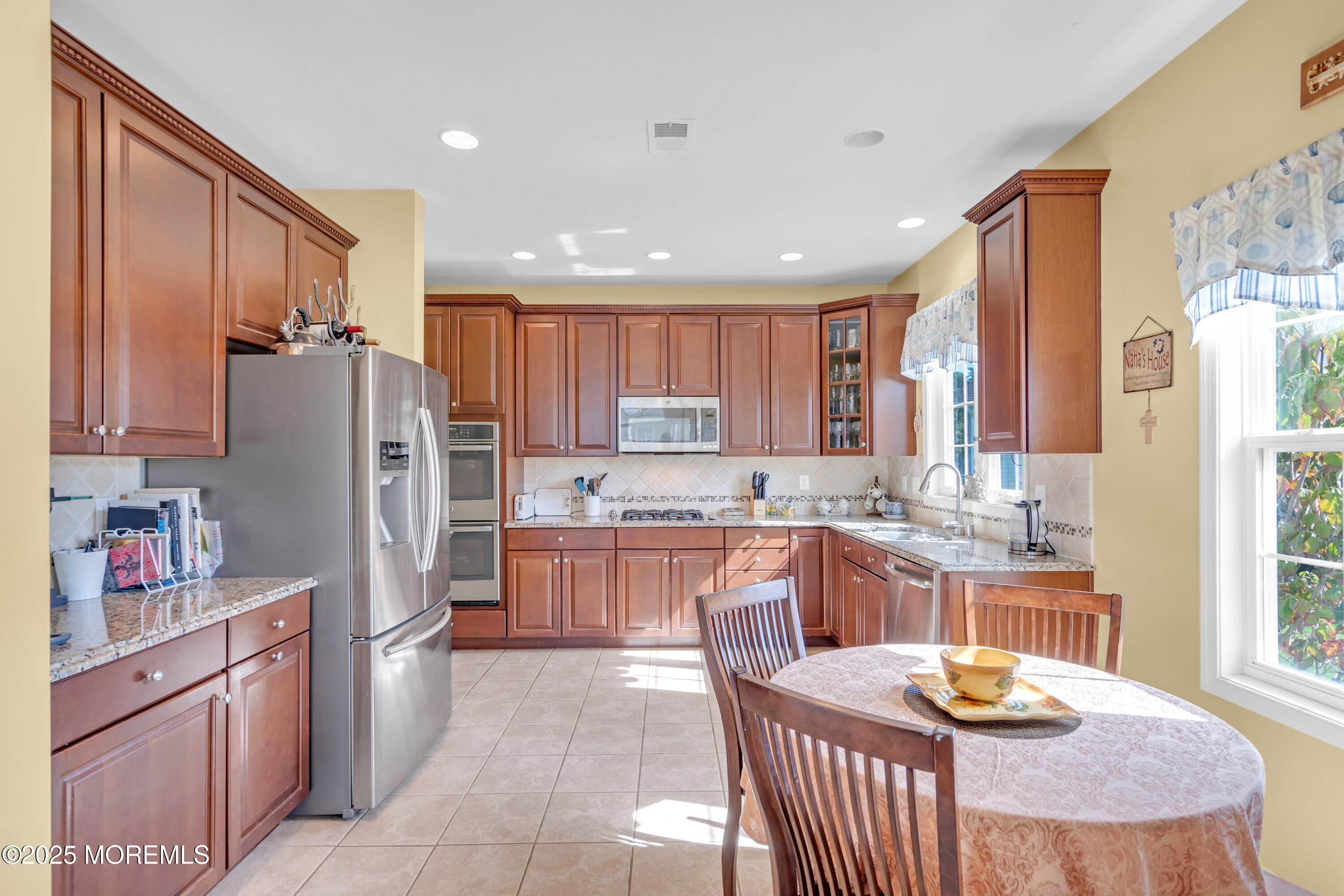 8 Ventnor Court Waretown, NJ 08758 - Photo 21 of 42 a kitchen with granite countertop stainless steel appliances a refrigerator a stove a sink a dining table and chairs
