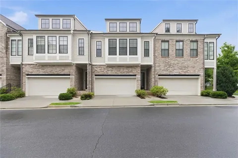 a front view of a house with yard and parking