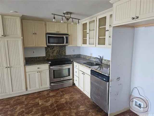 a bathroom with a granite countertop sink and a toilet
