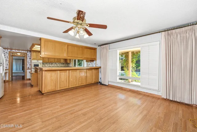 a kitchen with stainless steel appliances granite countertop a sink and cabinets with wooden floor