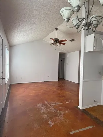 a view of a room with a chandelier fan and wooden floor