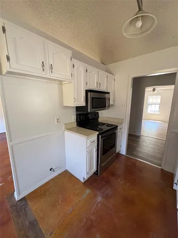 a kitchen with sink a microwave and cabinets