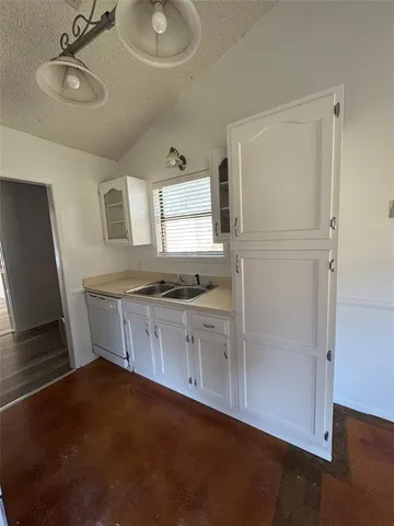 a kitchen with granite countertop white cabinets and white appliances