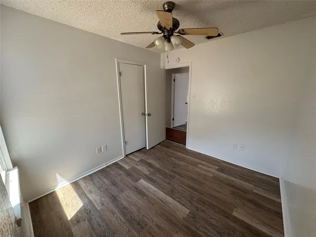 a view of empty room with a window and a ceiling fan