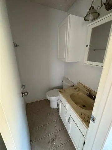a bathroom with a granite countertop sink and toilet
