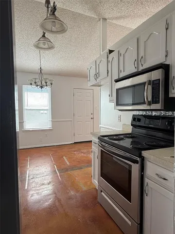 a kitchen with granite countertop a stove a sink and a microwave