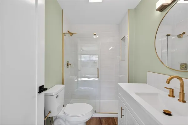 a bathroom with a sink a toilet and shower