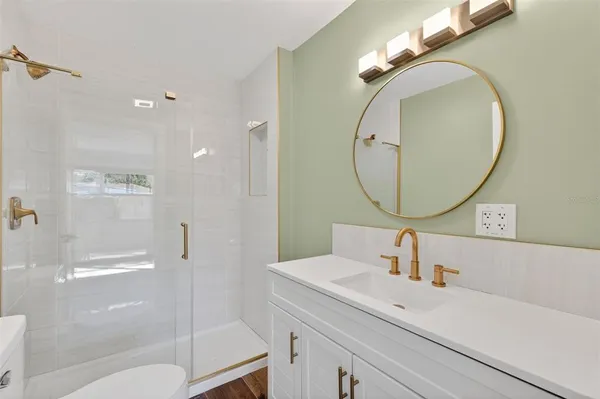 a bathroom with a sink a toilet and a mirror