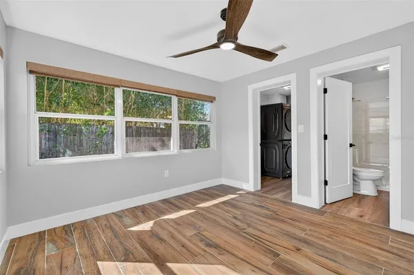 a view of empty room with wooden floor and window
