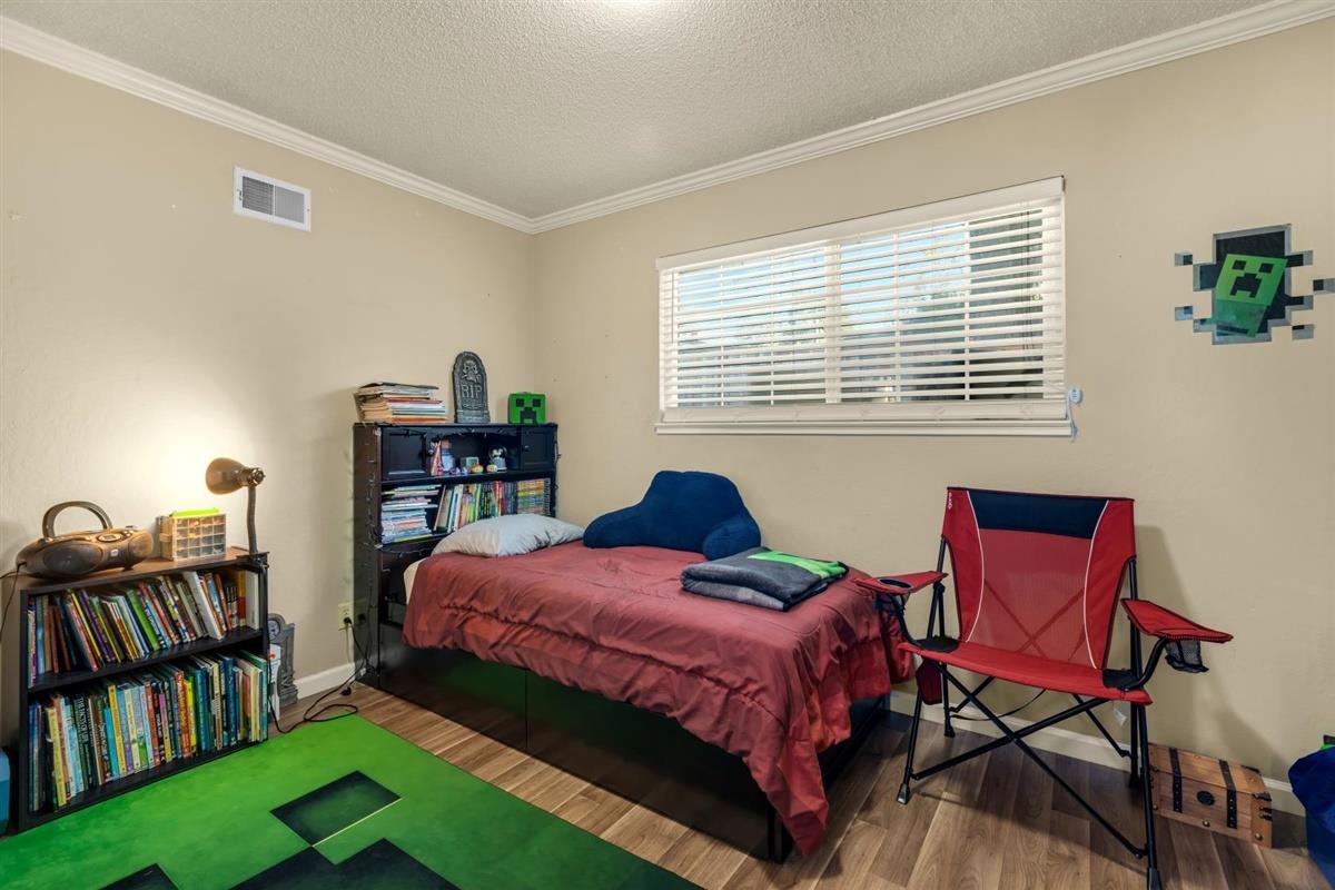 406 Pine Street, Unit A Capitola, CA 95010 - Photo 20 of 32 a bedroom with a bed and a bookshelf with wooden floor