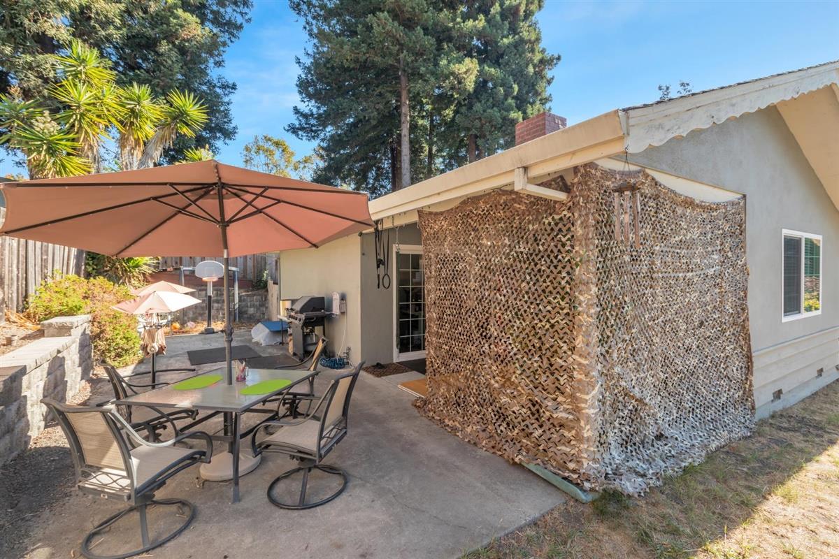 406 Pine Street, Unit A Capitola, CA 95010 - Photo 26 of 32 a patio with a table and chairs under an umbrella