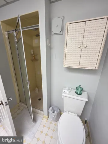 a white toilet sitting next to a bathroom sink and a mirror