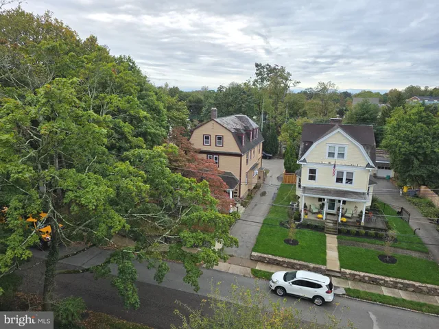 an aerial view of a house with a garden and large trees