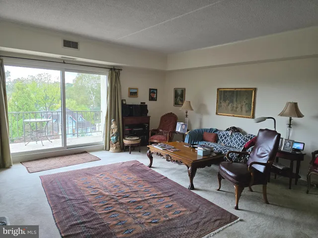 a living room with furniture large window and a table