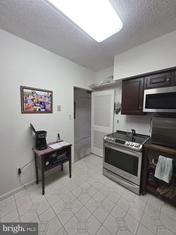 a kitchen with granite countertop a stove a sink and a refrigerator
