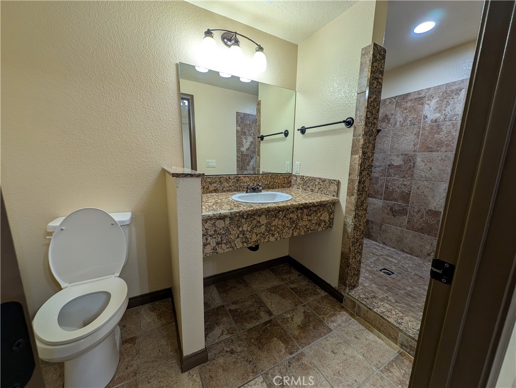 27160 Vista Road, Unit 8 Helendale, CA 92342 - Photo 12 of 12 a bathroom with a sink a toilet and shower