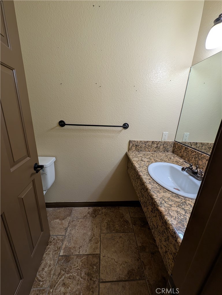 27160 Vista Road, Unit 8 Helendale, CA 92342 - Photo 7 of 12 a bathroom with a granite countertop sink and a mirror