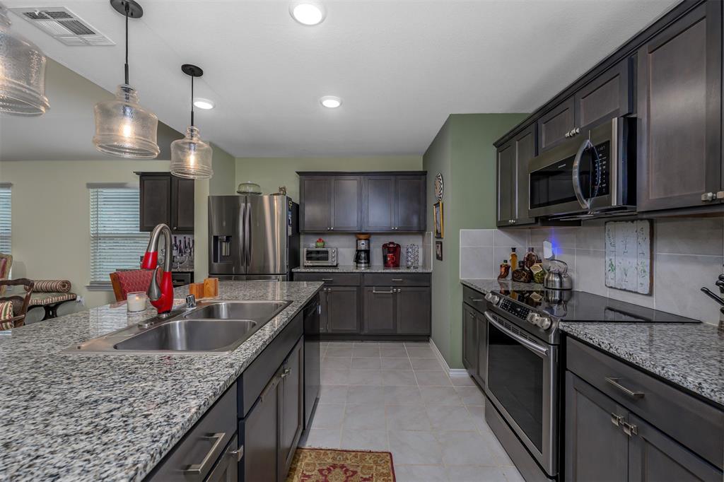 910 Community Way Royse City, TX 75189 - Photo 7 of 27 a kitchen with stainless steel appliances granite countertop a sink stove and refrigerator