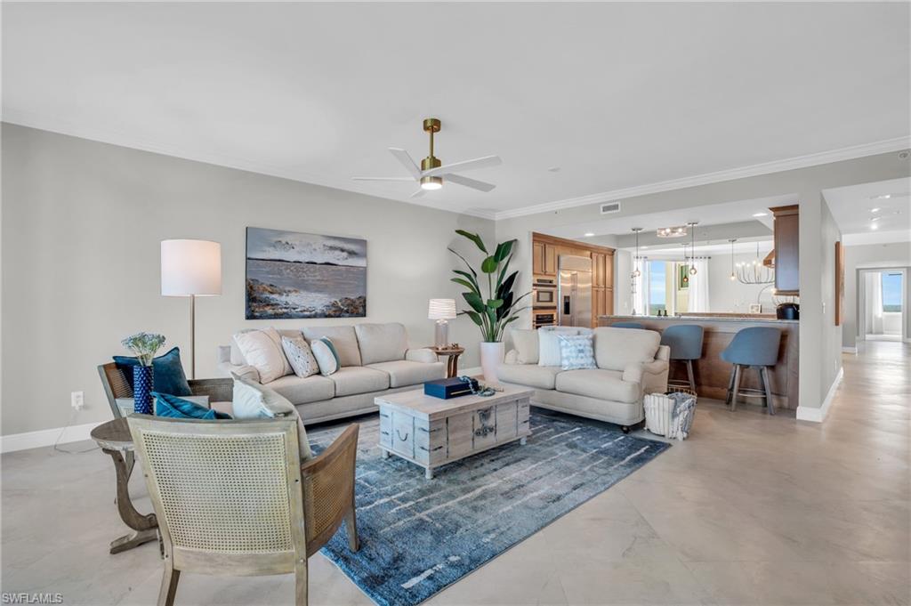 265 Indies Way, Unit 1402 Naples, FL 34110 - Photo 17 of 45 Living room featuring crown molding, plenty of natural light, and ceiling fan