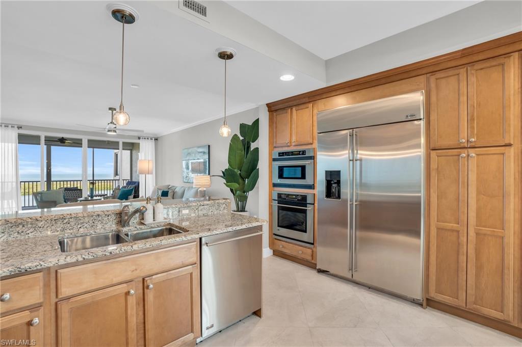 265 Indies Way, Unit 1402 Naples, FL 34110 - Photo 23 of 45 Kitchen featuring stainless steel appliances, hanging light fixtures, sink, and light stone counters