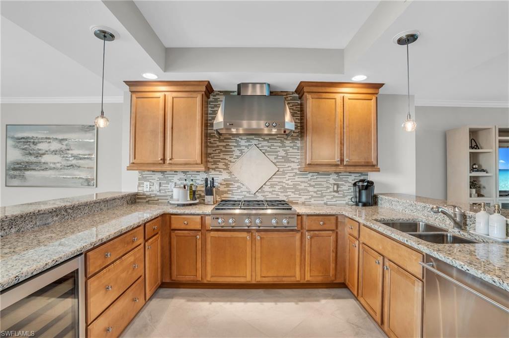 265 Indies Way, Unit 1402 Naples, FL 34110 - Photo 24 of 45 Kitchen with decorative light fixtures, wine cooler, wall chimney exhaust hood, sink, and light tile floors