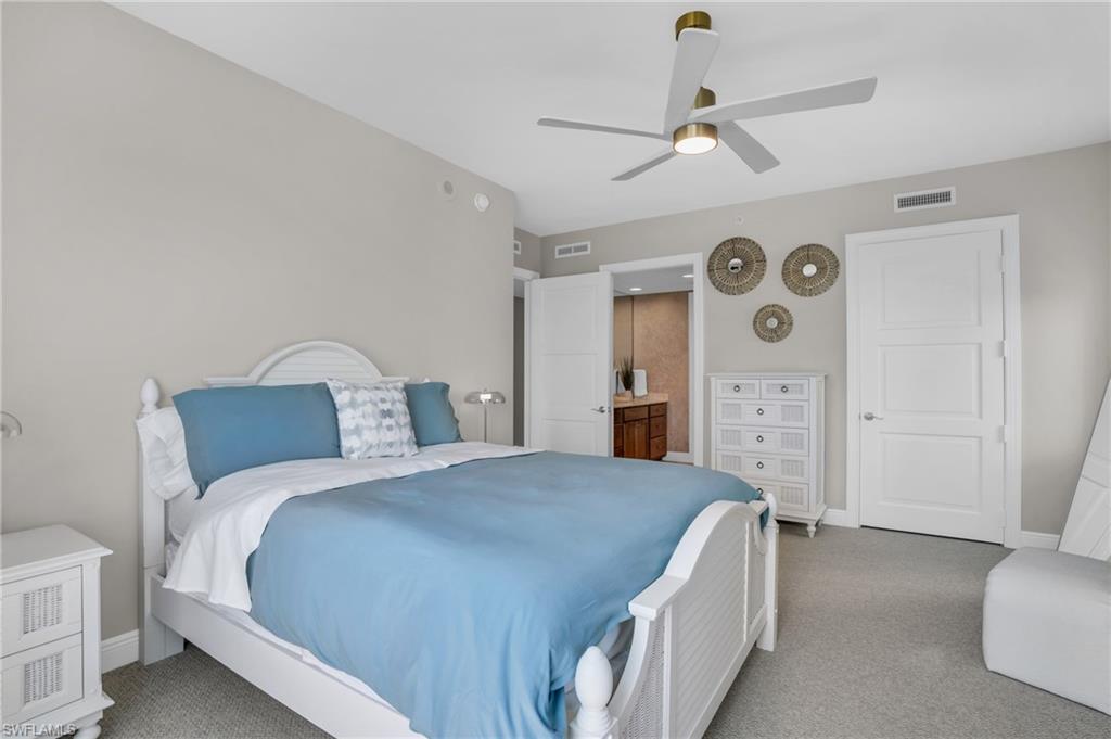 265 Indies Way, Unit 1402 Naples, FL 34110 - Photo 35 of 45 Carpeted bedroom with ensuite bathroom and ceiling fan