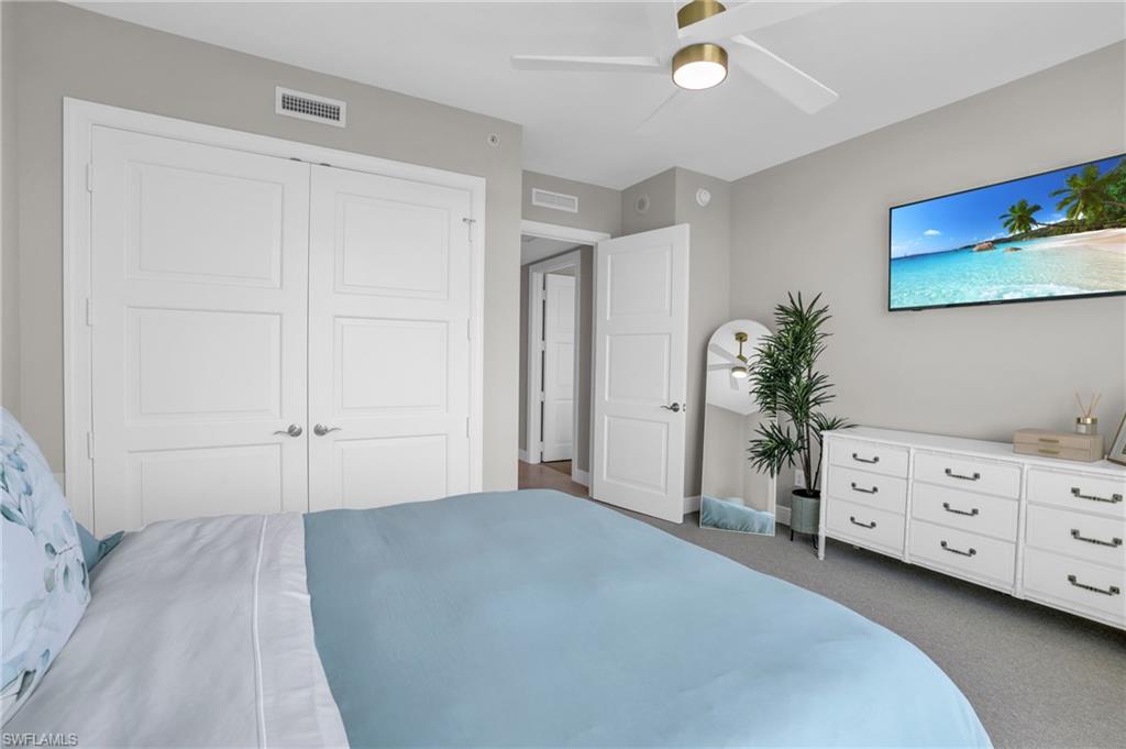 265 Indies Way, Unit 1402 Naples, FL 34110 - Photo 38 of 45 Bedroom featuring ceiling fan, a closet, and dark colored carpet