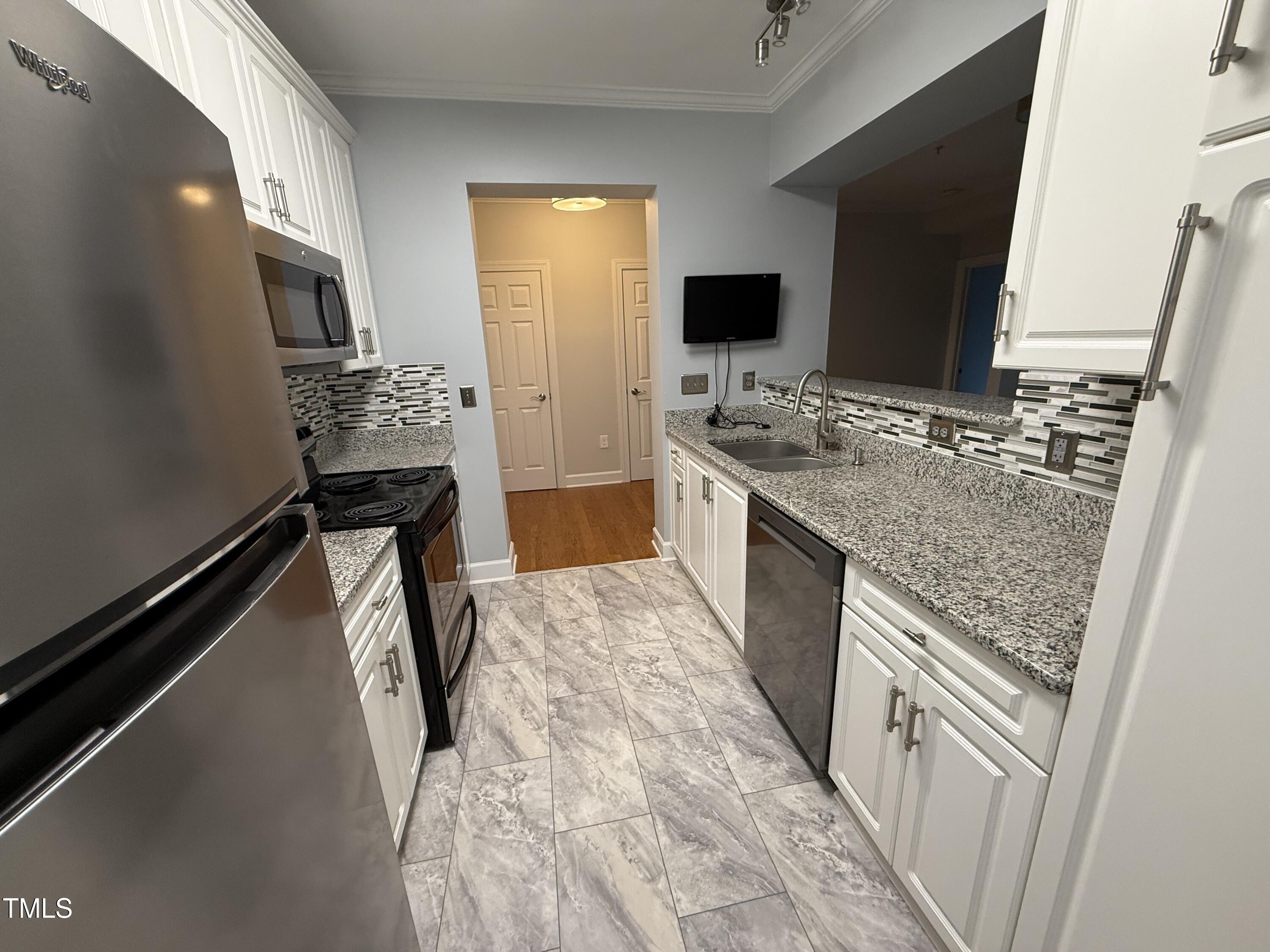 108-201 Northbrook Drive Raleigh, NC 27609 - Photo 22 of 32 a kitchen with stainless steel appliances granite countertop a stove and a refrigerator