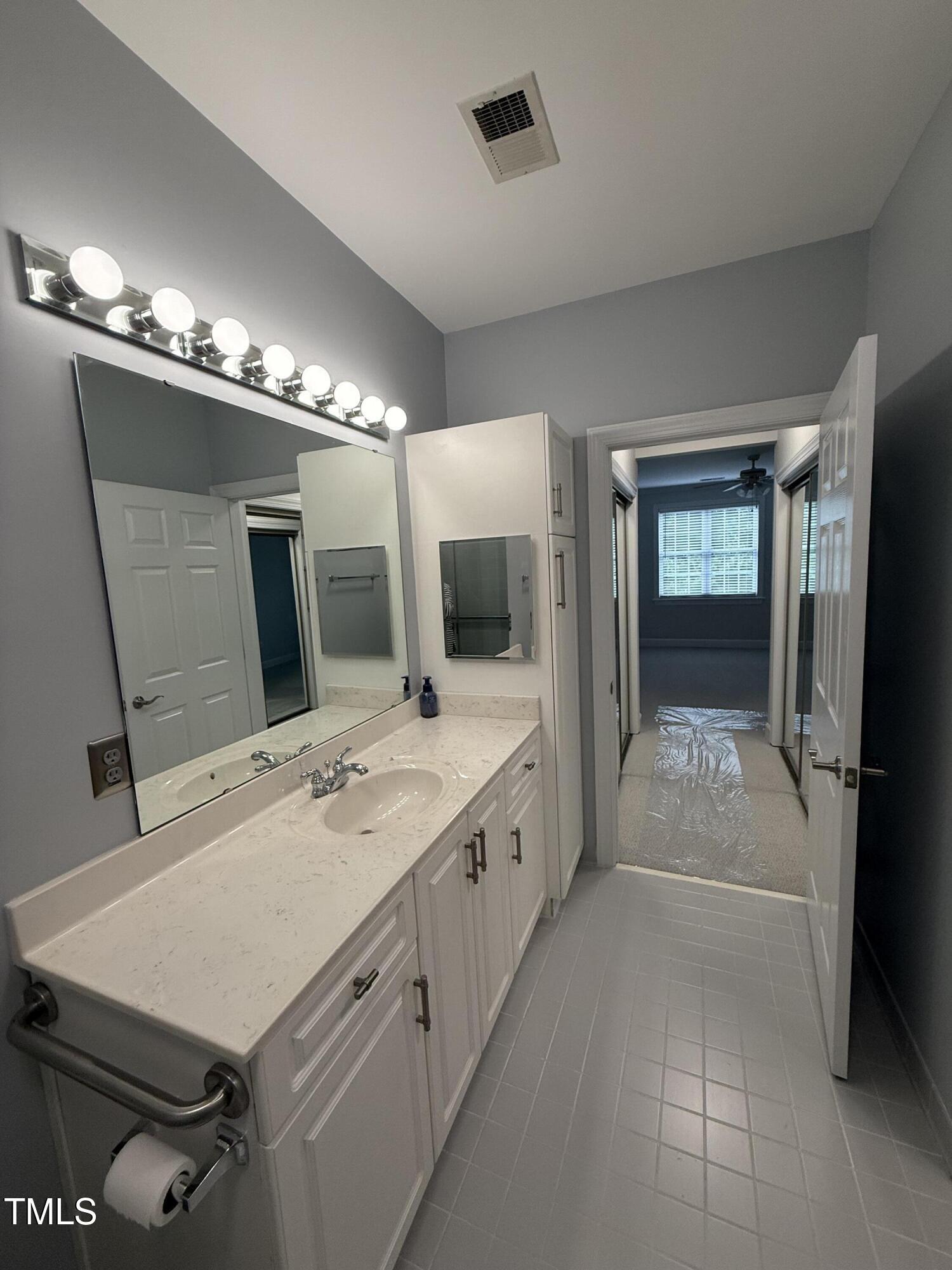 108-201 Northbrook Drive Raleigh, NC 27609 - Photo 27 of 32 a bathroom with a sink a large mirror and a shower