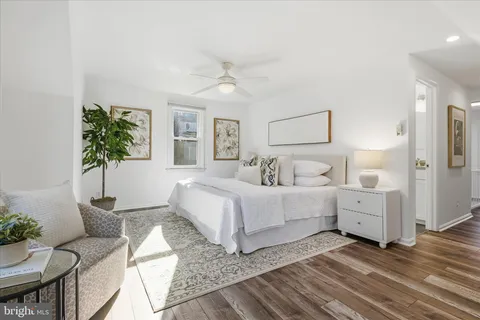 a spacious bedroom with a bed and wooden floor