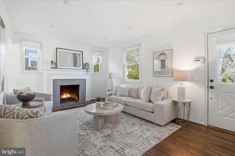 a living room with furniture a fireplace and a window