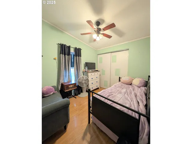 a bedroom with a bed and wooden floor