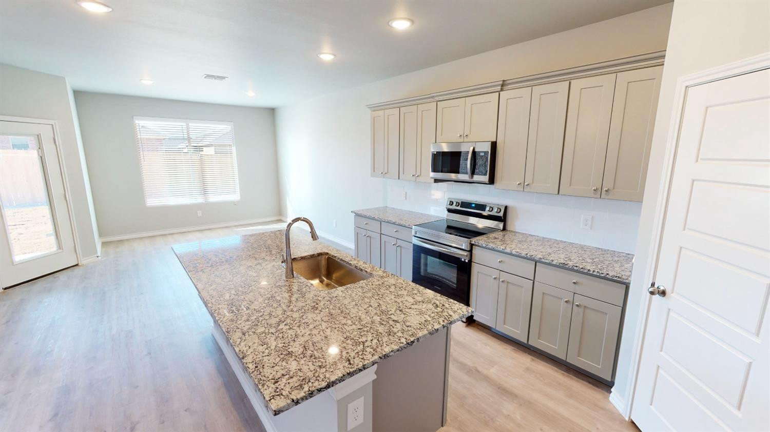 5804 Waverly Lubbock, TX 79407 - Photo 15 of 26 a kitchen with granite countertop kitchen island stainless steel appliances a stove sink and microwave