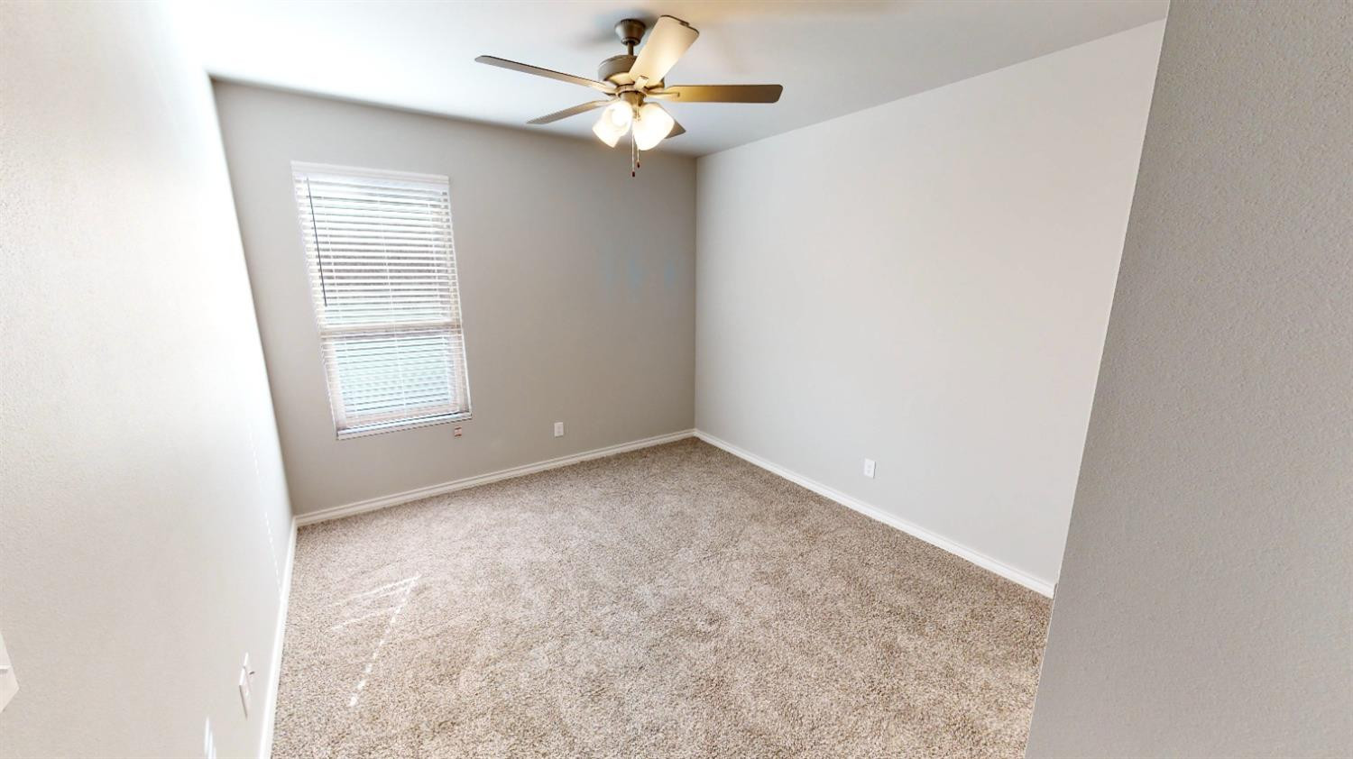 5804 Waverly Lubbock, TX 79407 - Photo 8 of 26 an empty room with a window and a fan